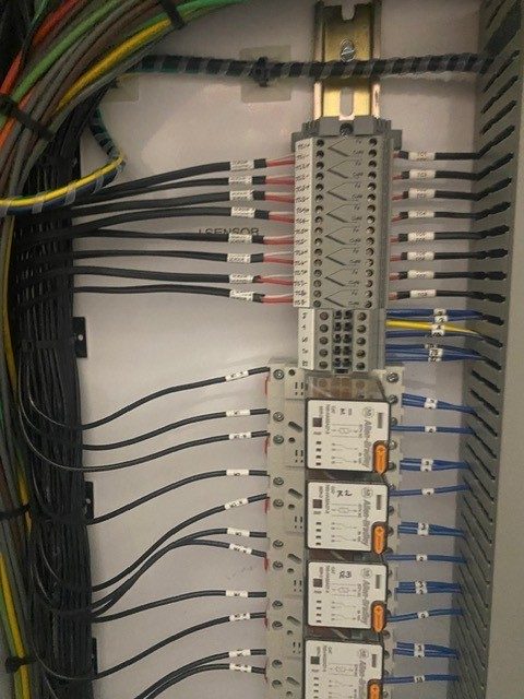 Detail view of thermocouple sensor terminations and end-of-run monitor relays in a freezer floor control panel